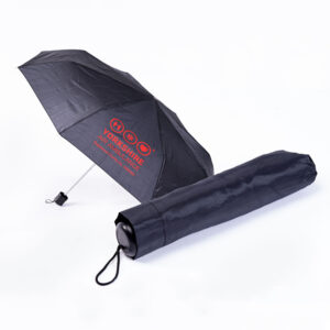 Two black umbrellas, one open and one closed and in it's cover. You can see on the open one that it carries the red Yorkshire Air Ambulance logo.