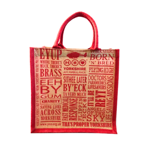 Jute shopping bag with red handles and trim, and red writing.