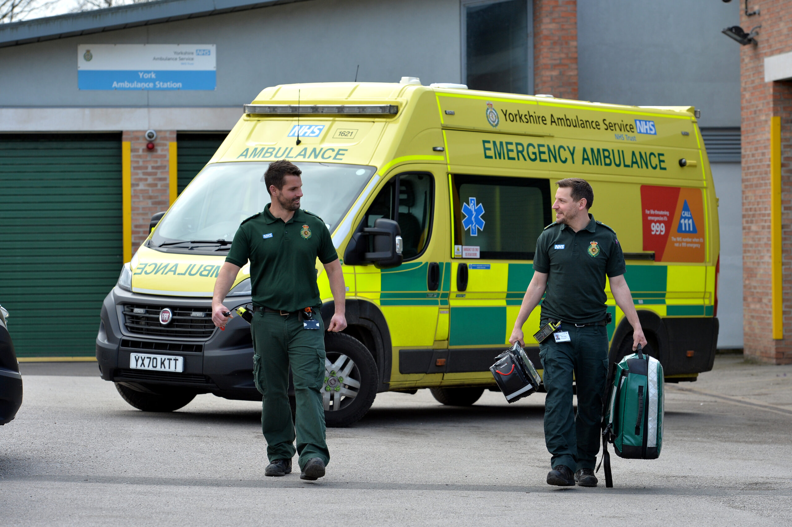Two paramedics standing in front of an ambulance