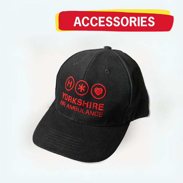 A black baseball cap with the red Yorkshire Air Ambulance logo on the front. There is a graphic above the hat with the word 'ACCESSORIES'