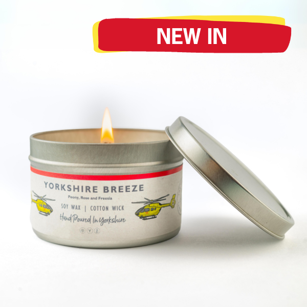 A candle with a graphic above with the words 'NEW IN'