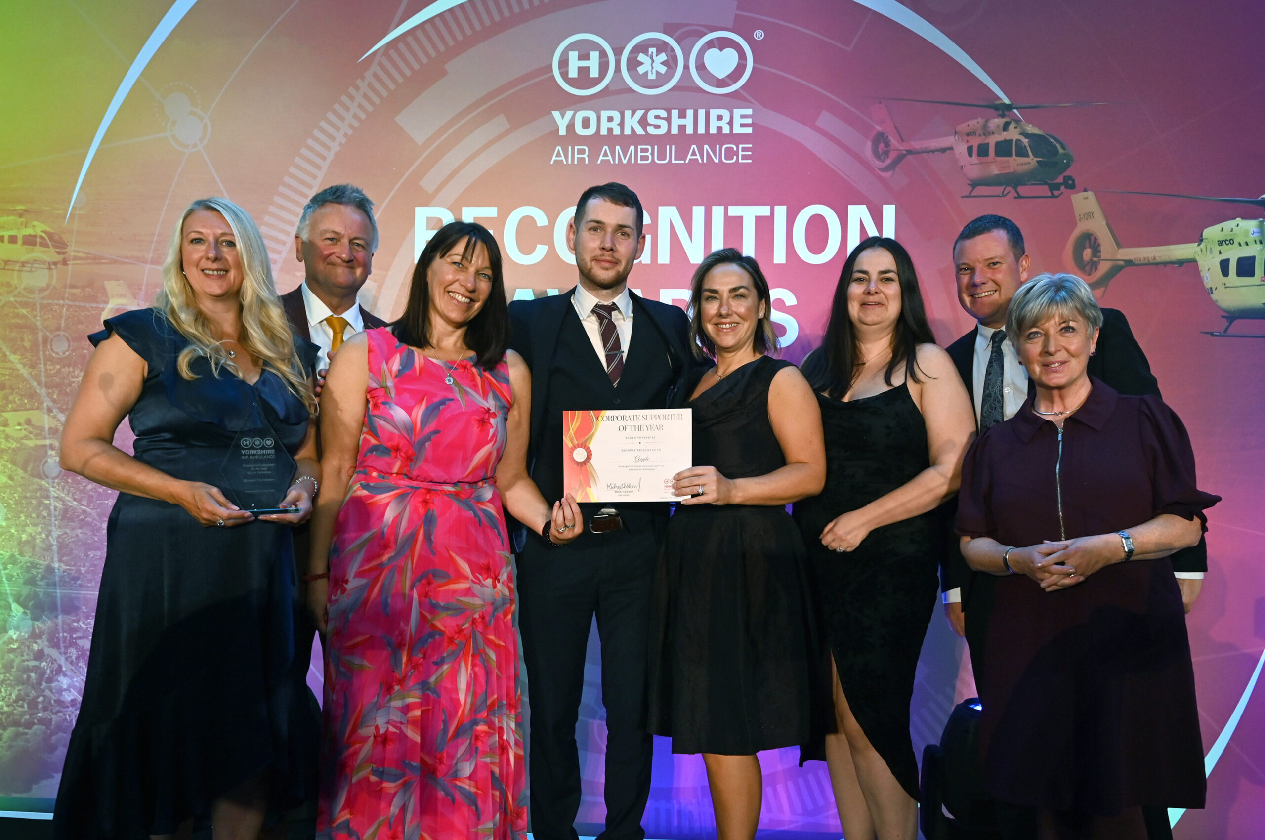 Group of people on stage claiming award